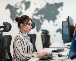Casual business woman working on desktop computer in modern open plan startup office interior. Selective focus Casual businesswoman working on a desktop computer in modern open plan startup office interior. Selective focus. High-quality photo